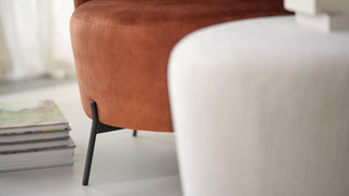 Détail d'un pouf Mobitec Bolero rouille sur pieds noirs à côté d'un pouf blanc