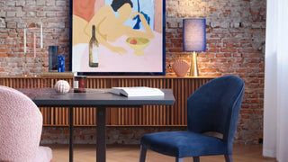 Lifestyle image of pink and blue Mobitec Cuori chairs at a table with sideboard and lamp