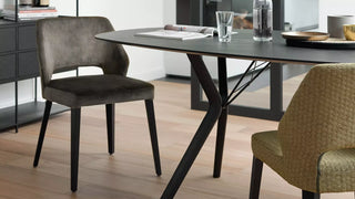 Lifestyle image of anthracite and green Mobitec Lena chairs at a black table