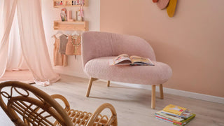 Lifestyle image of a pink Mobitec Thalia loveseat in a pink room with rattan chair
