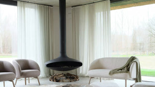 Lifestyle image of grey Mobitec Thalia armchairs and loveseat around a suspended fireplace