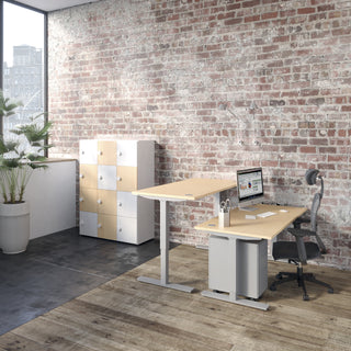 Lifestyle image of a Buronomic Locker Eko 12-compartment locker in white and beech by a sit-stand desk
