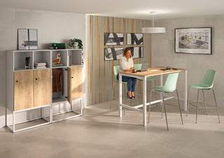 Lifestyle image of a Buronomic Locker Eko unit in white and Nebraska by a high table with green stools