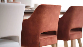 Detail of rust Mobitec Lena chairs with open back at a table