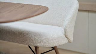 Détail de l'assise en bouclette écrue de la banquette Mobitec Neo près d'une table en bois